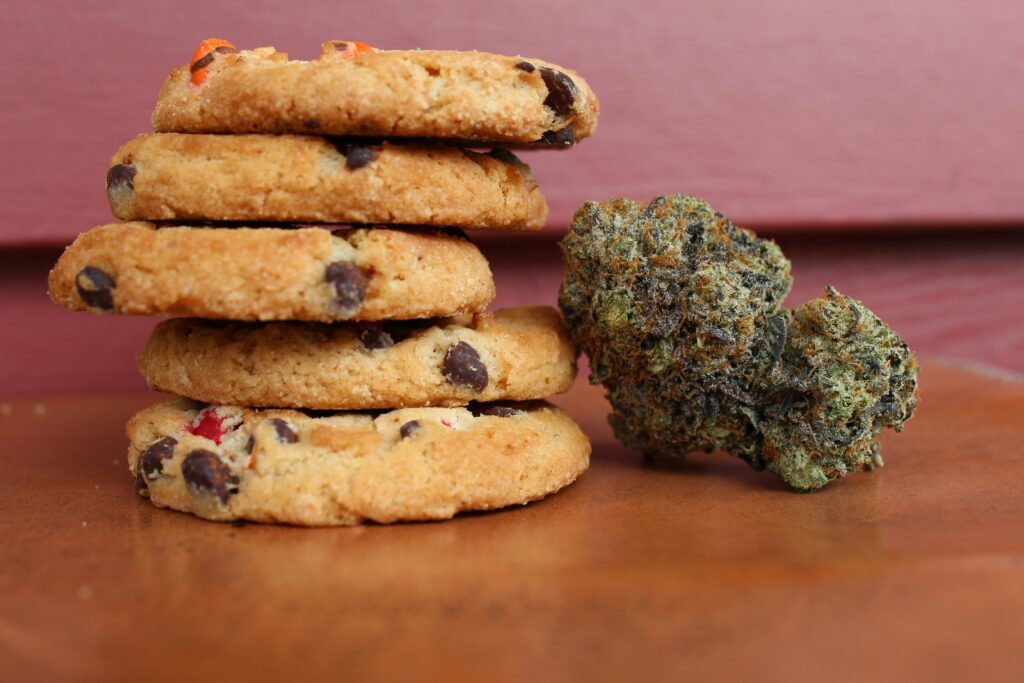 five cookies and a cannabis nugget sitting on a wooden table