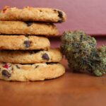 five cookies and a cannabis nugget sitting on a wooden table